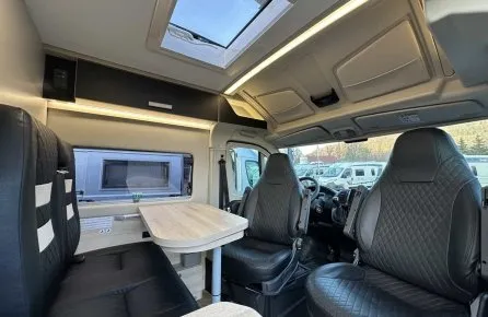 Intérieur d'un camping-car moderne avec sièges en cuir et table pliante