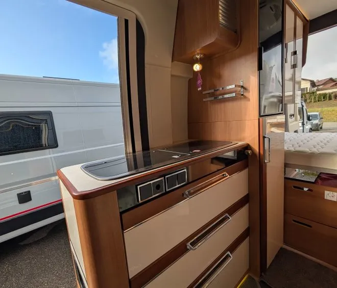 Intérieur d'un camping-car avec cuisine équipée et rangements en bois