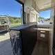 Intérieur d'un van aménagé avec vue sur l'extérieur et rangements intégrés