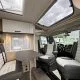 Intérieur moderne d'un camping-car avec sièges et table.