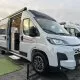 Camping-car Dethleffs blanc avec porte latérale ouverte sur un parking.