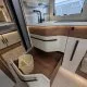 Cuisine moderne de camping-car avec évier, tiroir ouvert et poubelle intégrée