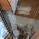 Salle de bain compacte dans un camping-car avec toilettes et lavabo en acier inoxydable