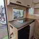 Cuisine moderne de camping-car avec plaque de cuisson et rangements