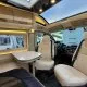 Intérieur d'un camping-car moderne avec sièges en cuir et table pliante.