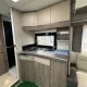 Cuisine compacte de caravane avec évier et rangements en bois clair