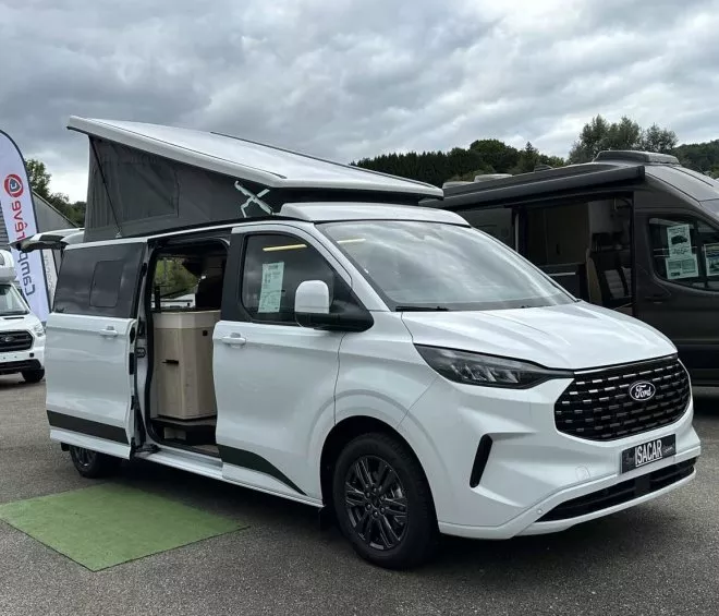 Van aménagé Ford blanc avec toit relevable sur un parking