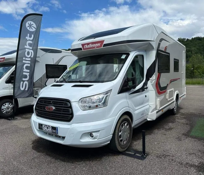 Camping-car Challenger exposé sur un parking avec bannière Sunlight en arrière-plan.