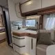 Cuisine moderne de camping-car avec évier, rangements et banquette.