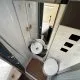Salle de bain compacte avec douche, lavabo et toilettes dans un camping-car moderne.