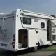 Camping-car Dethleffs stationné avec porte ouverte et porte-vélos à l'arrière.