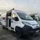Camping-car blanc Dethleffs avec porte ouverte sur un parking