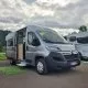 Fourgon aménagé Citroën gris stationné sur un parking, porte latérale ouverte