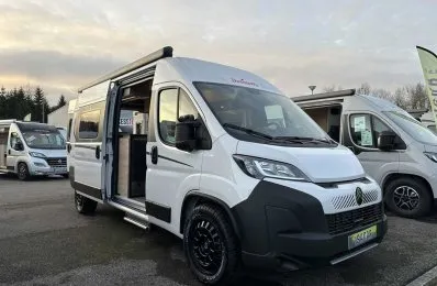 Camping-car blanc Dethleffs avec porte ouverte sur un parking