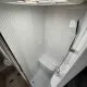 Douche compacte avec parois blanches et pommeau, dans un espace restreint de véhicule récréatif.