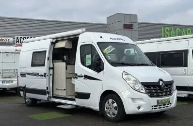 Camping-car Renault blanc stationné devant un concessionnaire