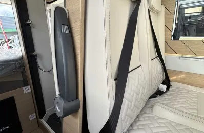 Siège de camping-car avec ceinture de sécurité et revêtement en cuir beige.