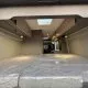 Intérieur d'un van aménagé avec lit double et rangements en bois clair