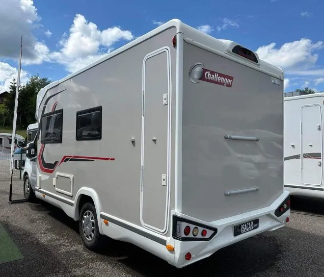 Camping-car Challenger stationné sur un parking sous un ciel bleu avec nuages