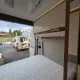 Intérieur d'un camping-car avec lit et rangements visibles