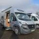 Camping-car Camperêve stationné sur un parking, porte latérale ouverte