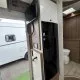Intérieur d'un camping-car moderne avec télévision et salle de bain visible.