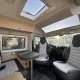 Intérieur d'un camping-car moderne avec sièges et table, éclairage naturel.