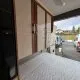 Intérieur d'un camping-car avec lit et placards en bois, stationné en extérieur.