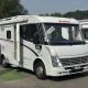 Camping-car Dethleffs blanc stationné sur un parking, porte ouverte