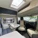 Intérieur d'un camping-car moderne avec sièges et table pliante.