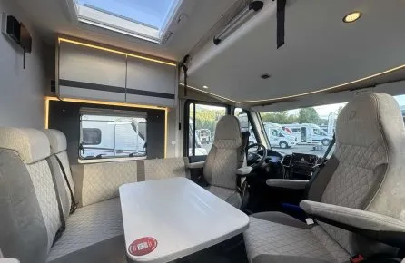 Intérieur d'un camping-car moderne avec sièges et table, éclairage LED