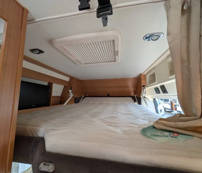 Intérieur d'un camping-car avec lit escamotable et éclairage intégré