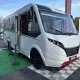 Camping-car Dethleffs blanc exposé sur un parking avec d'autres véhicules similaires.