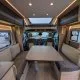 Intérieur d'un camping-car moderne avec table et banquettes grises