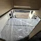 Intérieur d'un camping-car Campérêve avec lit double et rangement en bois