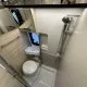 Salle de bain compacte avec douche, lavabo et toilettes dans un camping-car moderne.