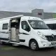 Camping-car Renault blanc stationné devant un concessionnaire