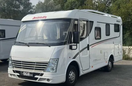Camping-car Dethleffs blanc stationné sur un parking, modèle d'occasion.