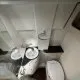 Salle de bain compacte avec lavabo, toilettes et douche dans un espace restreint.