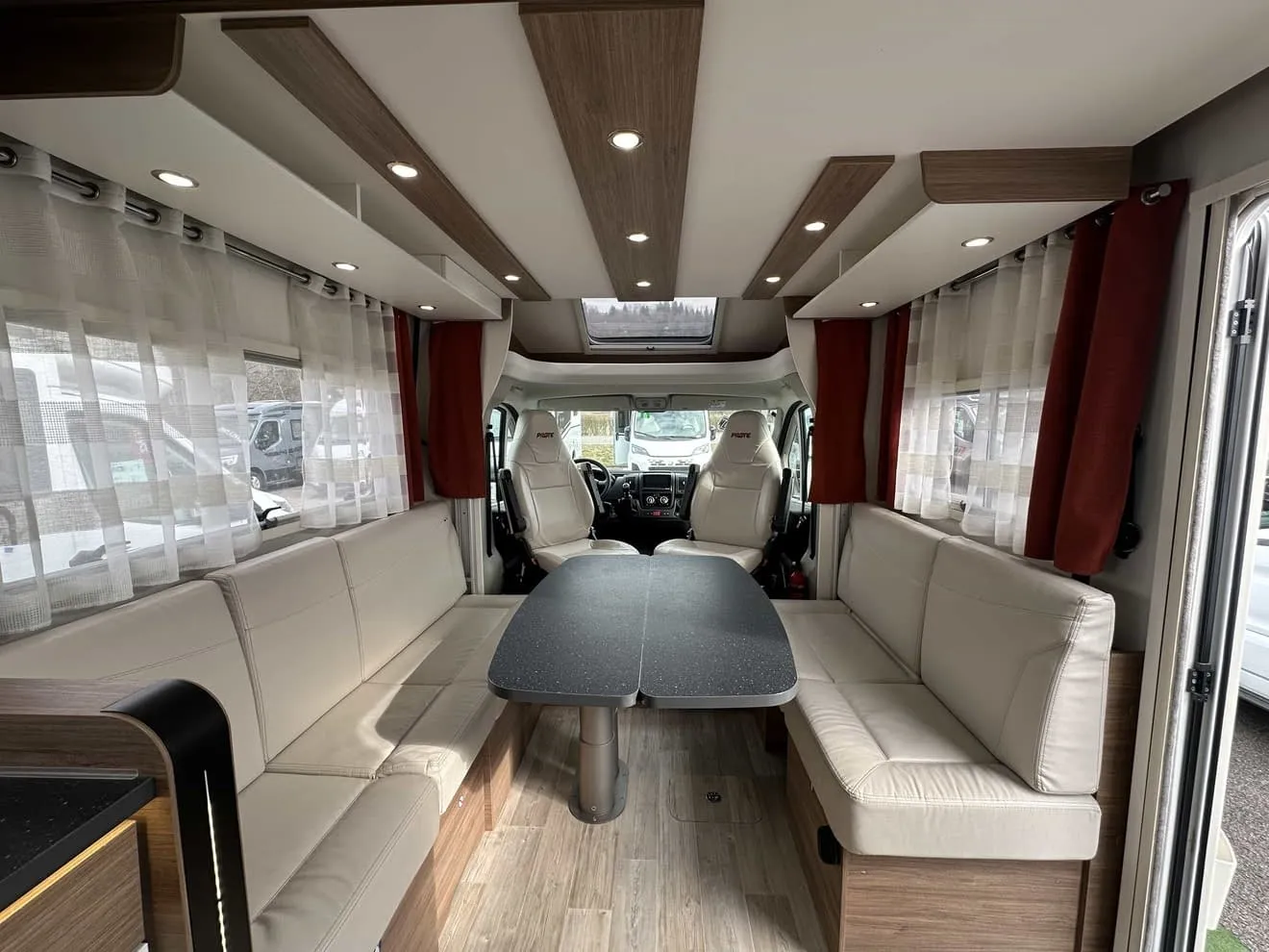 Intérieur d'un camping-car moderne avec sièges en cuir et table centrale