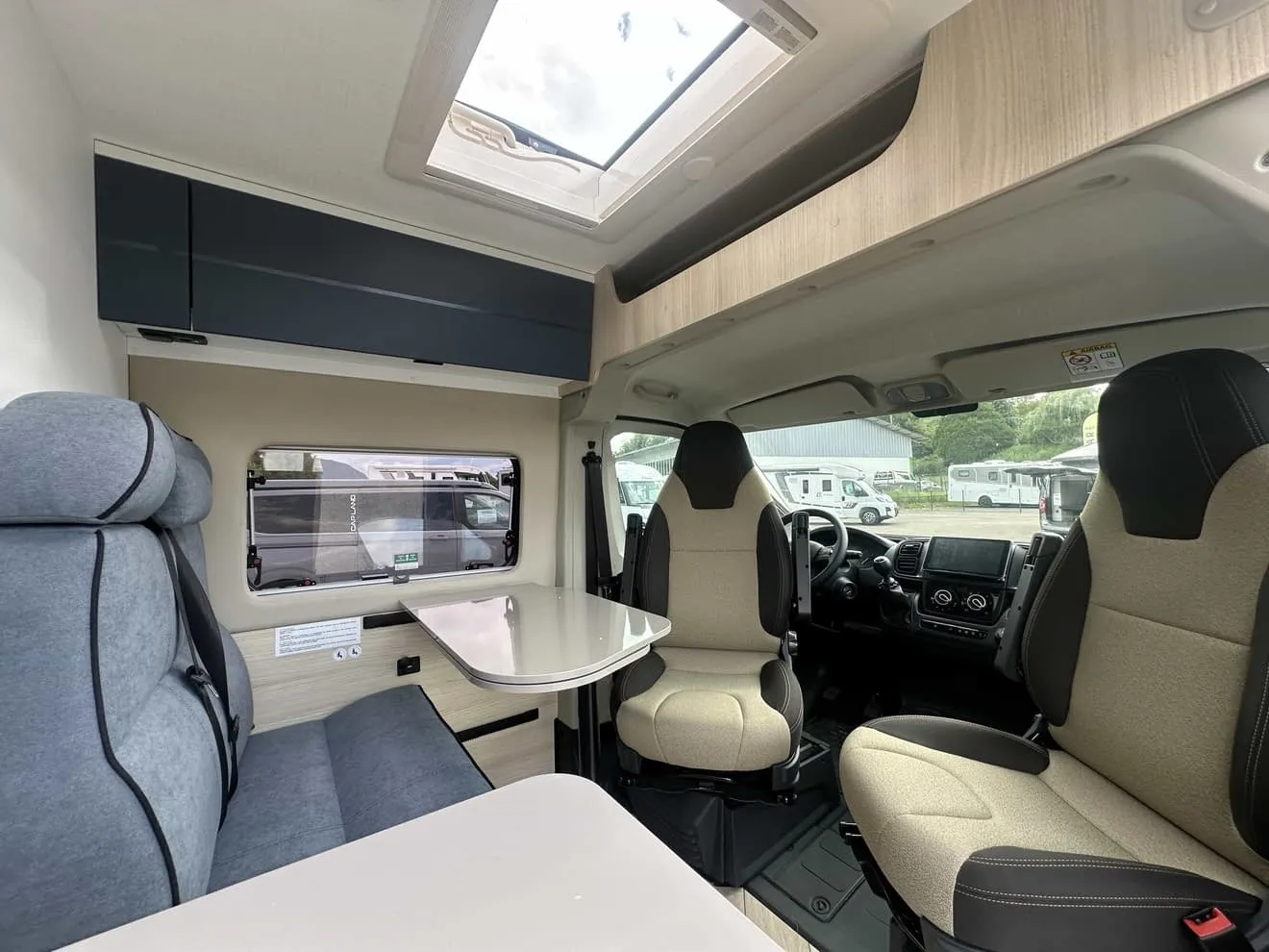 Intérieur d'un camping-car moderne avec sièges et table pliante.