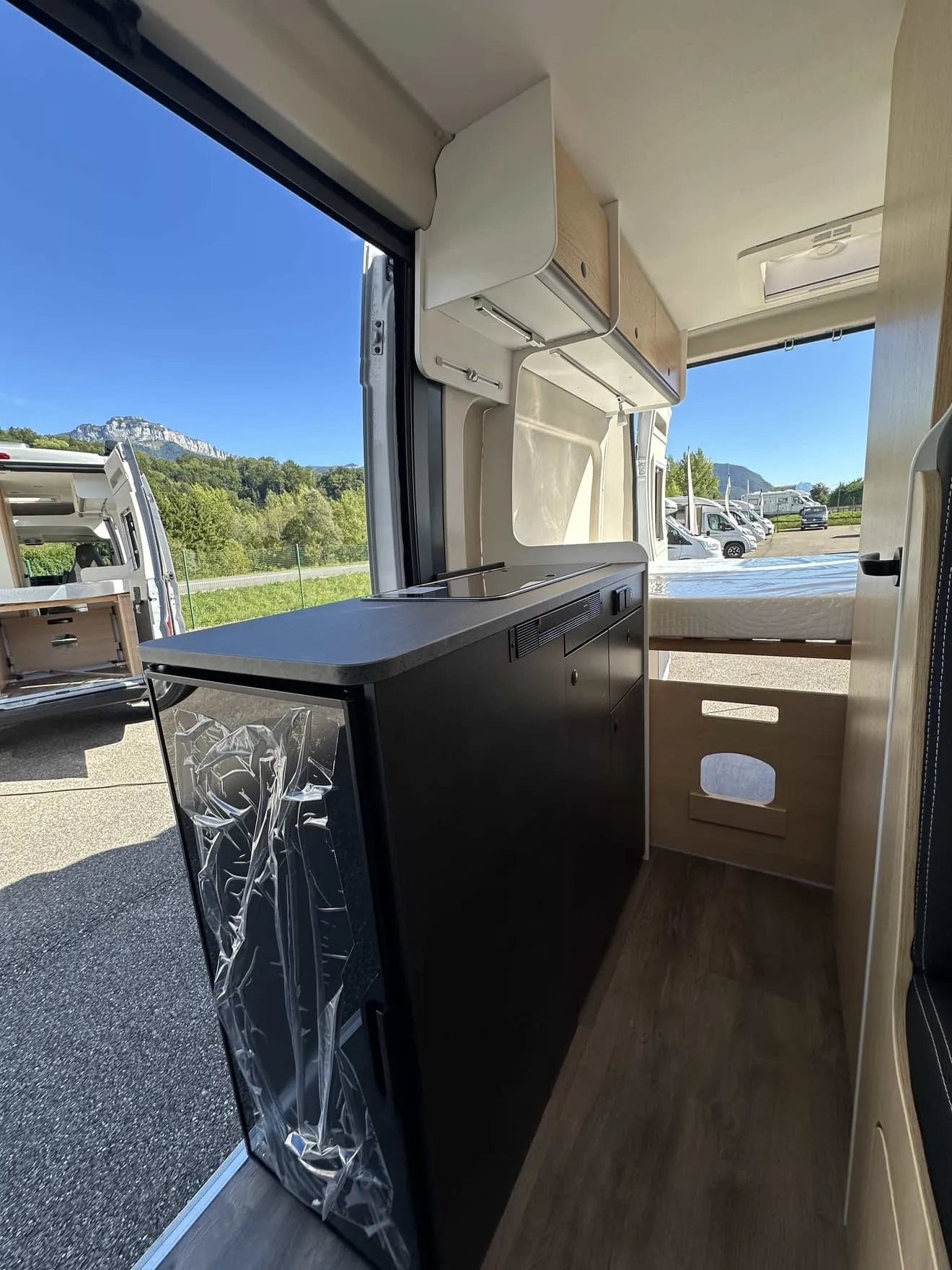 Intérieur d'un van aménagé avec vue sur l'extérieur et rangements intégrés