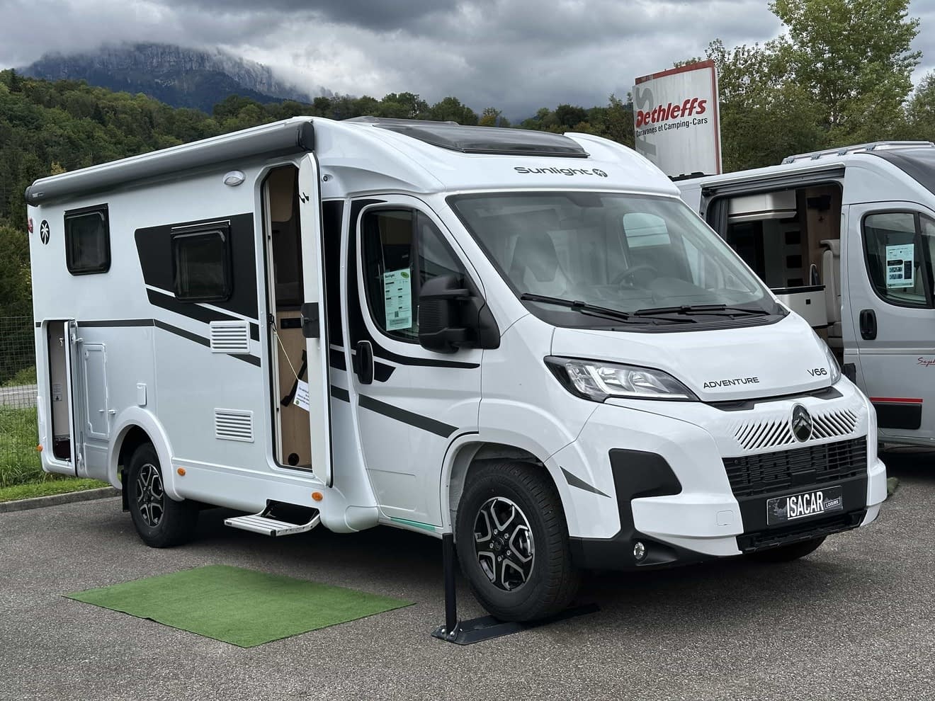 Camping-car Sunlight V66 blanc stationné devant un paysage montagneux
