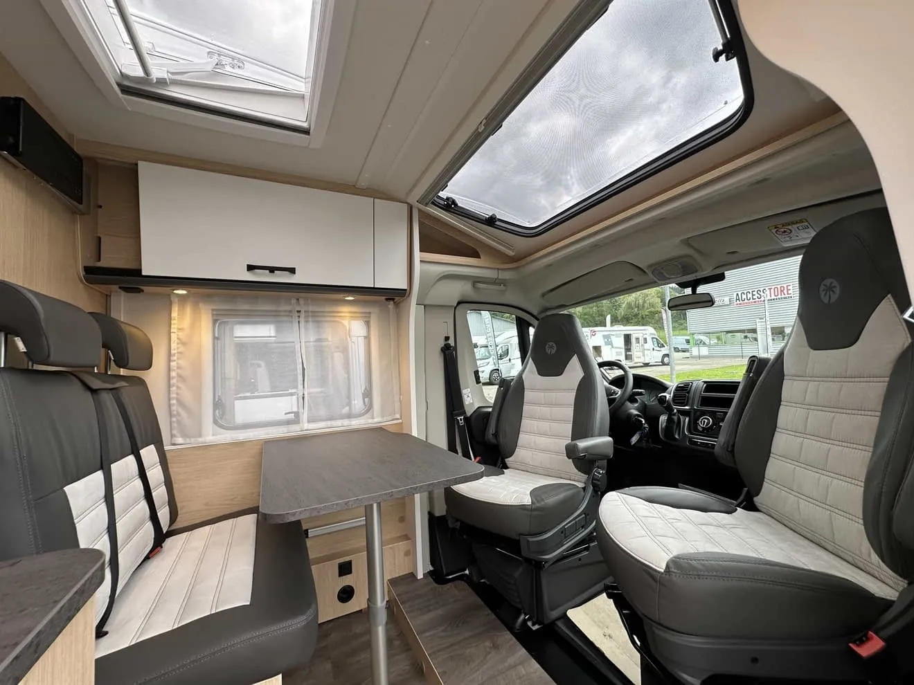 Intérieur moderne d'un camping-car avec sièges et table.