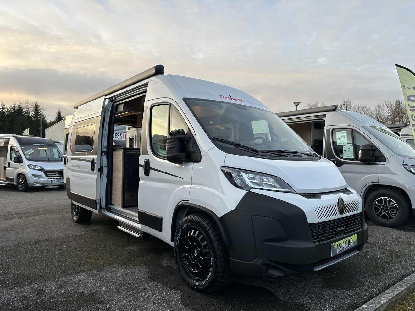 Camping-car blanc Dethleffs avec porte ouverte sur un parking