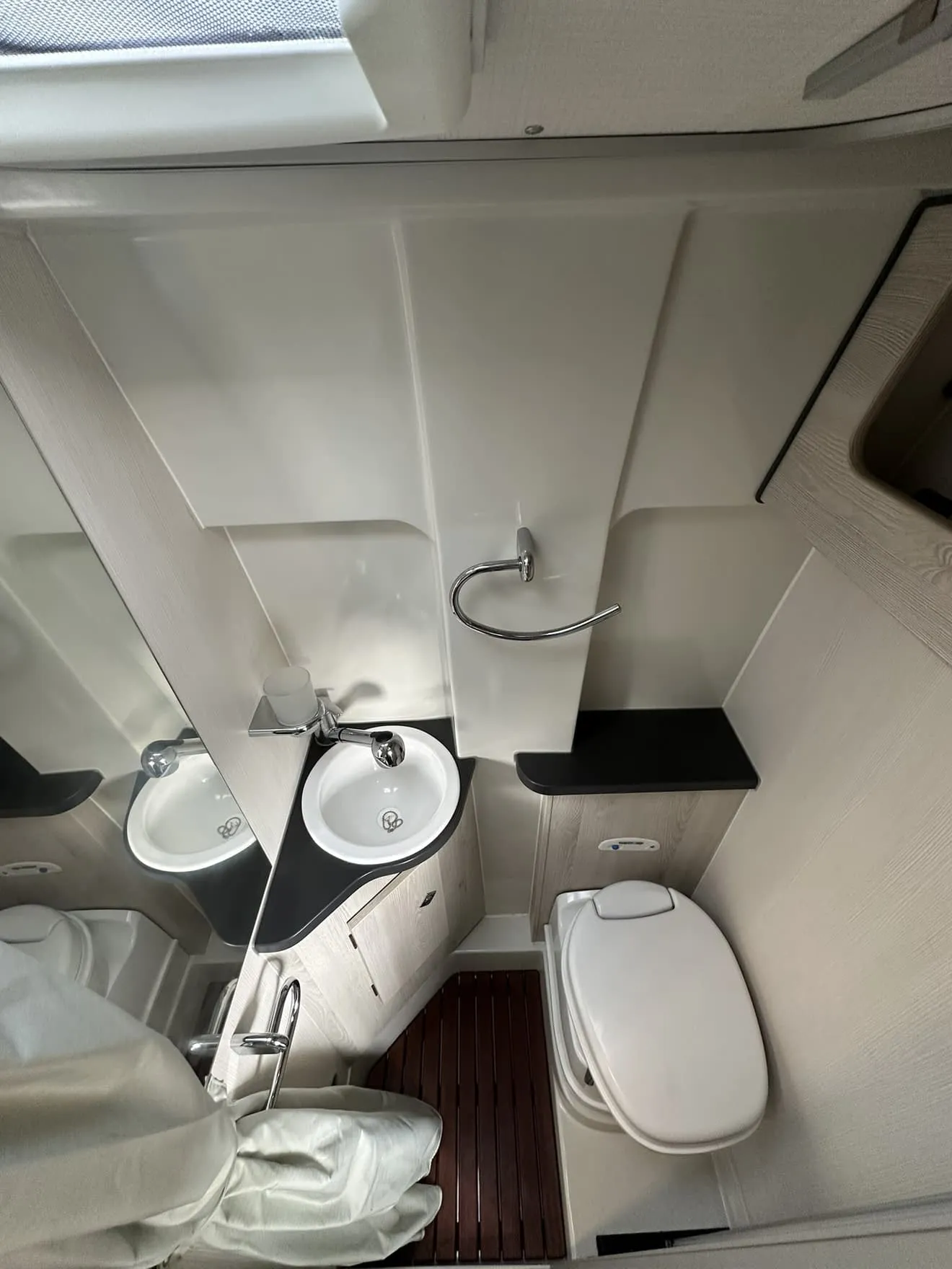 Salle de bain compacte avec lavabo, toilettes et douche dans un espace restreint.