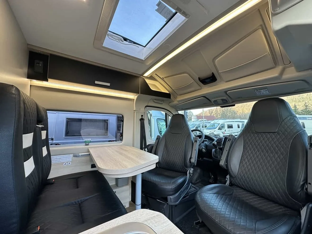 Intérieur d'un camping-car moderne avec sièges en cuir et table pliante